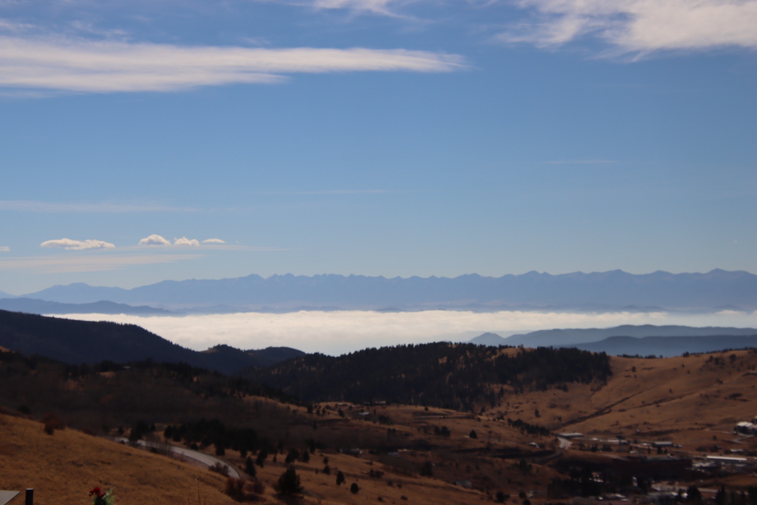 Blue sky above clouds gathered in a mountain valley